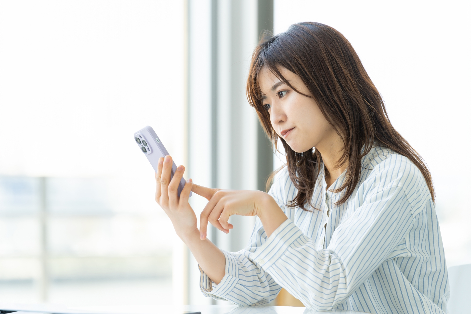 スマホで調べ物をする女性